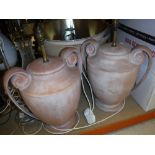 A pair of modern terracotta table lamps of scroll handled urn form.