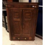 A 19th Century oak and inlaid two door hanging corner cupboard with drawer flanked by two dummy