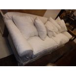 A modern cream floral design upholstered scroll arm sofa on turned legs Size approx.
