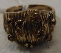A 9 carat gold garnet set ring with textured bark decoration, size K,