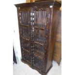 A modern Indian stained hard wood food cupboard with two iron railed doors enclosing shelves size