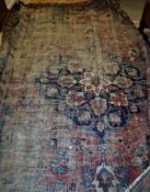 A Persian rug the central panel set with floral decorated medallion on a blue and red ground,
