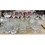 A large collection of cut glass wines and beakers to include five cranberry cut glass Bohemian wine