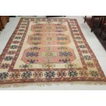 A Caucasian rug, the central panel set with three lozenge shaped medallions on a cream ground,
