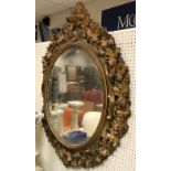 A Victorian carved giltwood and gesso framed oval wall mirror with grape and vine decoration in the