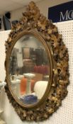 A Victorian carved giltwood and gesso framed oval wall mirror with grape and vine decoration in the