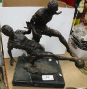 A modern bronze sculpture of two footballers.