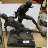 A modern bronze sculpture of two footballers.