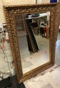 A modern carved giltwood framed wall mirror in the Rococo style Size approx.