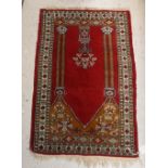 A Bokhara rug the central panel set with Mirhab style design on a red ground within a stepped red,
