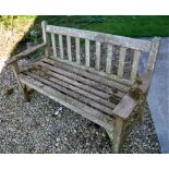 A Cannock Gates weathered teak garden table, together with two garden bench seats,