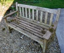 A Cannock Gates weathered teak garden table, together with two garden bench seats,
