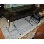 A smoked glass topped centre table on chrome framed A shaped trestle end supports Size approx.