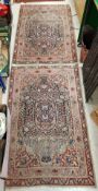 A pair of Kirman rugs with centre medallions on a deep blue ground within a red and pink ground