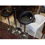A Chrome framed black glass topped bar table and two adjustable bar stools of similar design and a
