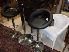 A Chrome framed black glass topped bar table and two adjustable bar stools of similar design and a