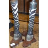 A pair of Zebra leg ashtray and cigarette lighter on carved wooden bases as "Africa" (ashtray top