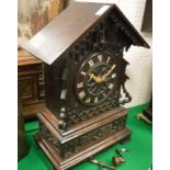 A late 19th Century carved oak cased mantel cuckoo clock,