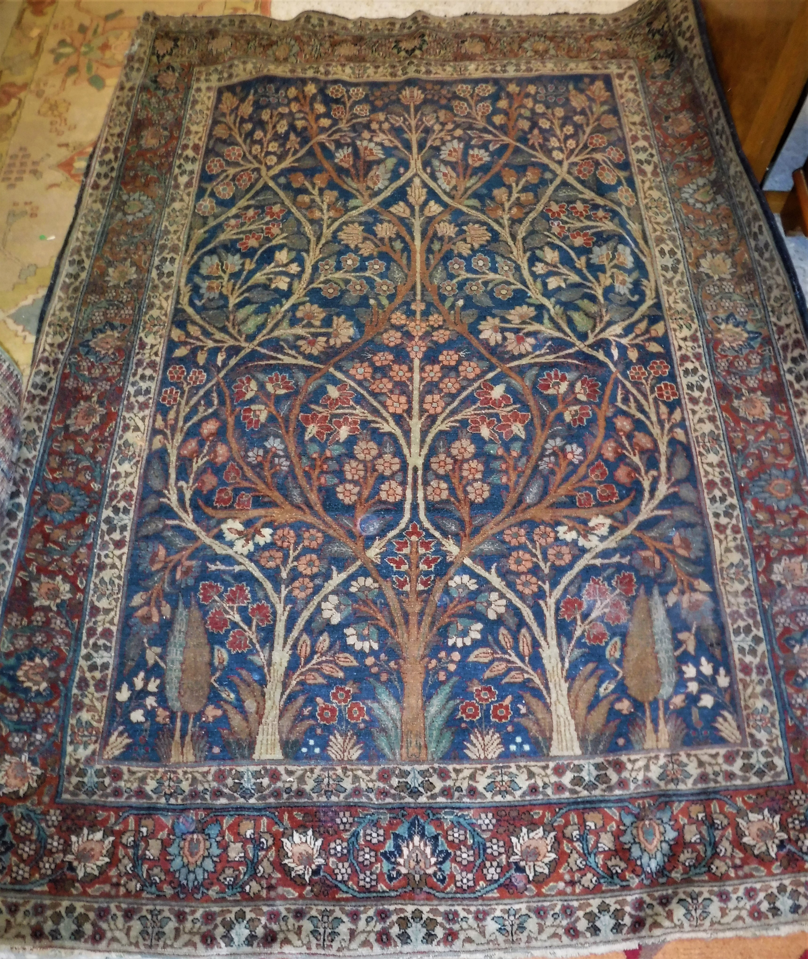 A Kashan rug, the central panel set with tree and foliate decoration on