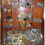 A wooden jewellery box containing various earrings and brooches and necklaces to include a