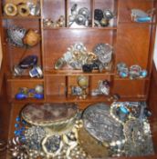 A wooden jewellery box containing various earrings and brooches and necklaces to include a