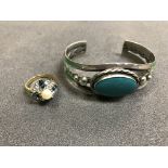 A yellow metal stone and pearl set dress ring together with a silver bangle with turquoise stone