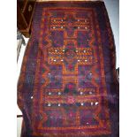 A Belouch rug the central panel set with three cross shaped medallions on a dark plum and black