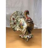 A 19th century french pottery turkey figure with floral decoration in the manner of Delphin Massier.