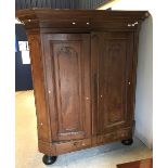 A 19th Century Dutch oak kas of typical form with canted sides opening to reveal three shelves over