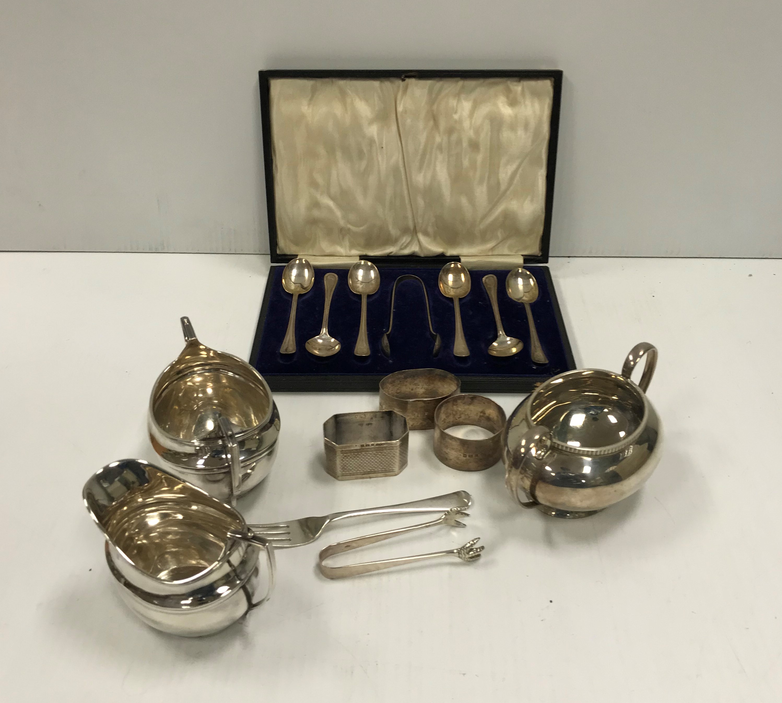 A collection of silver wares comprising a cased set of six silver teaspoons and sugar tongs,