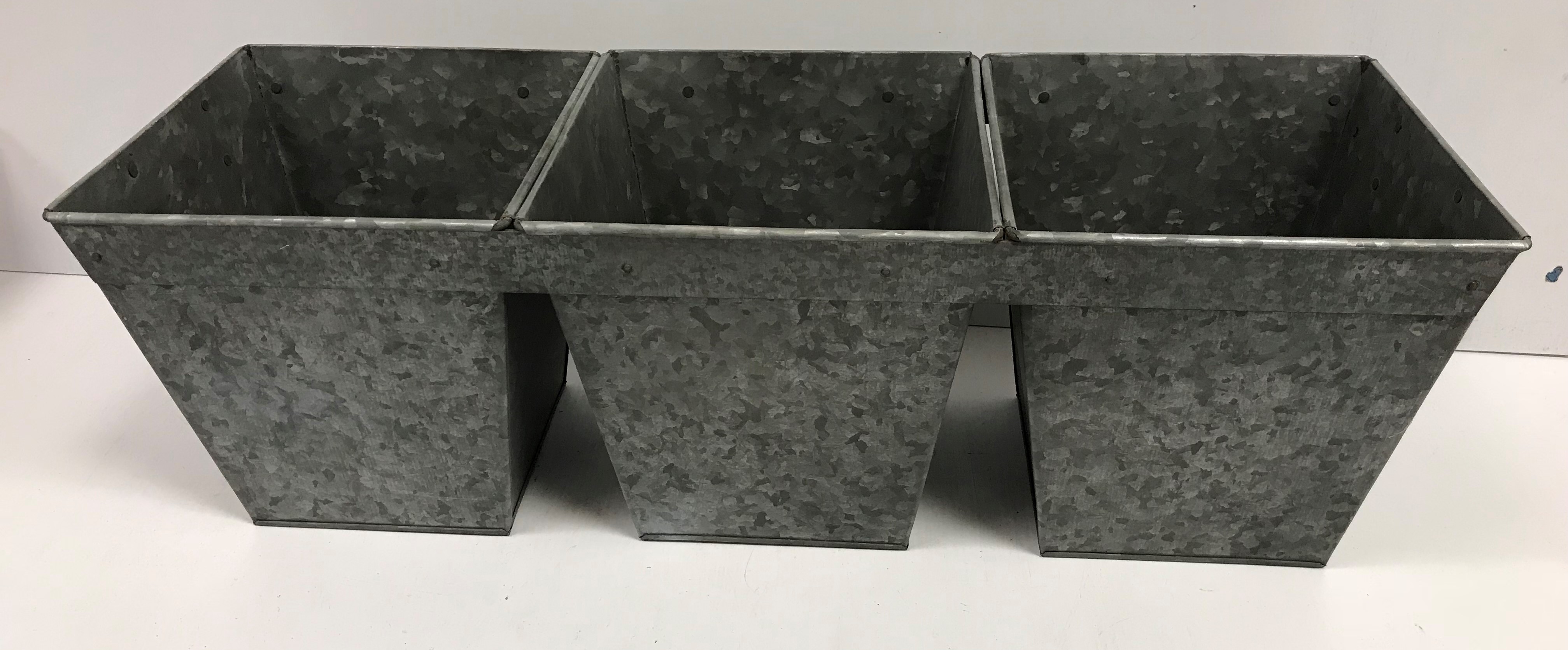 A set of three interconnected galvanised planters