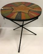 A painted metal circular folding table,
