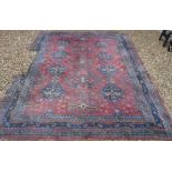 A Persian rug with all over floral medallion decoration on a plum ground,