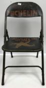 A painted metal folding chair inscribed "Michelin"