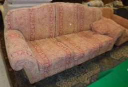 A modern terracotta / gold upholstered floral decorated sofa on turned legs to castors in the