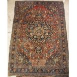 A Persian rug with centre medallion on a plum ground with all over floral decoration,