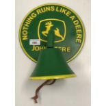 A painted cast metal bell on sign inscribed "Nothing Runs Like a Deere - John Deere"