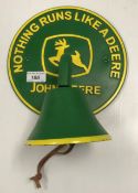 A painted cast metal bell on sign inscribed "Nothing Runs Like a Deere - John Deere"