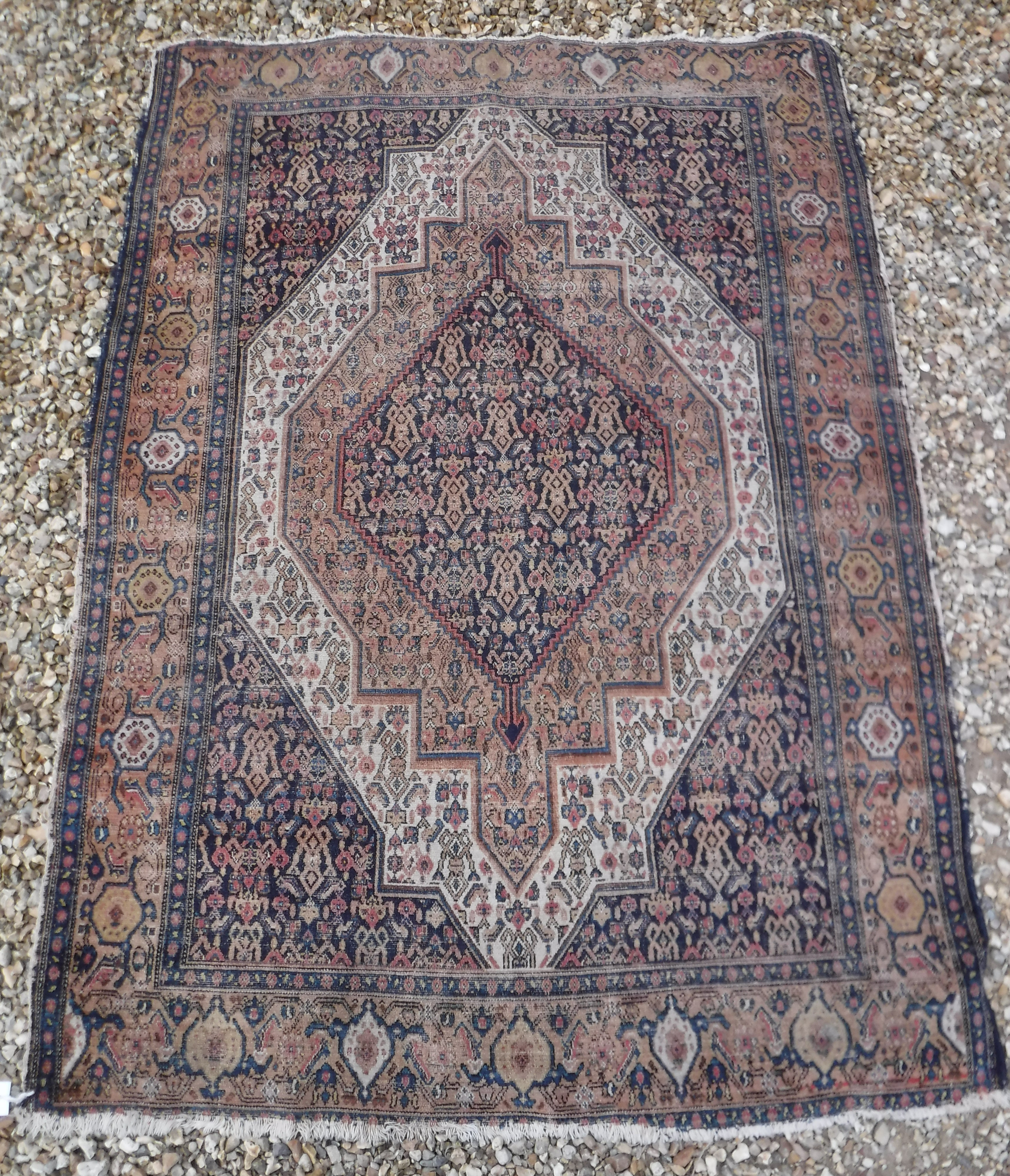 A Caucasian rug with blue stylised medallion decorated lozenge shaped medallion on a fawn / cream