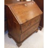 An 18th Century elm bureau the sloping fall enclosing a basic fitted interior over two drawers with