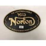 A modern painted cast metal sign "The Unapproachable Manx Norton - The World's Best Road Holder"