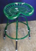 A pair of green painted cast iron "tractor seat" stools