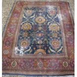 A Persian rug with all over floral medallion decoration in reds, greens and ochre on a blue ground,