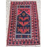 A Turkish prayer rug with stylised eagle wing medallions on a deep blue ground within a red ground