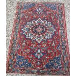 A Caucasian rug with central flower decorated star burst centre medallion on a floral decorated red