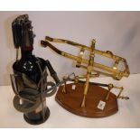 A modern lacquered brass wine cradle on mahogany base,