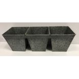 A set of three interconnected galvanised planters