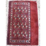 A Bokhara Juval rug with all over stylised medallion decoration on a red ground,
