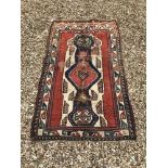 A Kasak rug, the central panel set with geometric design on a cream and red ground,