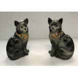 A pair of Staffordshire glazed pottery figures of seated cats with glass eyes,